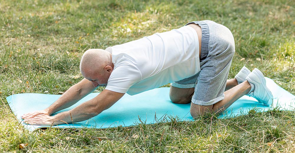 elderly man doing yoga to prevent falls