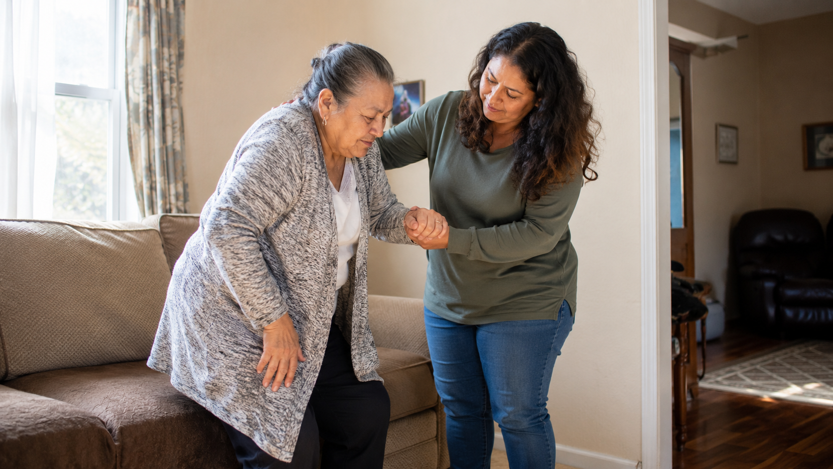 Family caregiver helping an older adult stand safely at home in Holyoke or Chicopee, Massachusetts